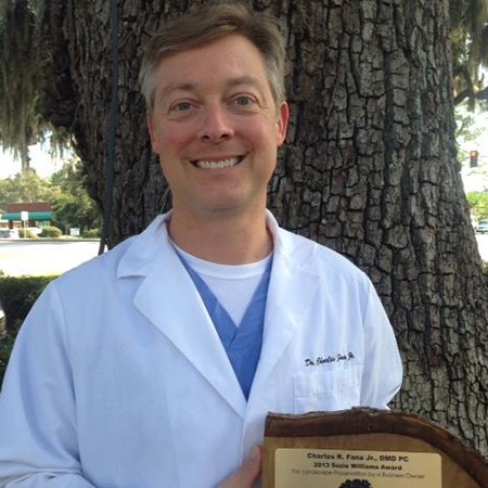 Dr. Fana smiling with plaque