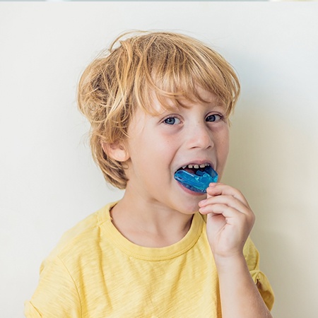 Young boy placing sports mouthguards